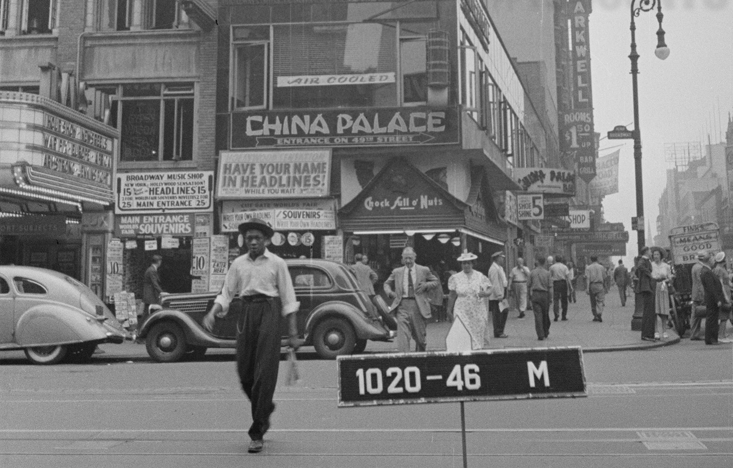 Historic photo of Manhattan, store signs in the background.
                                           