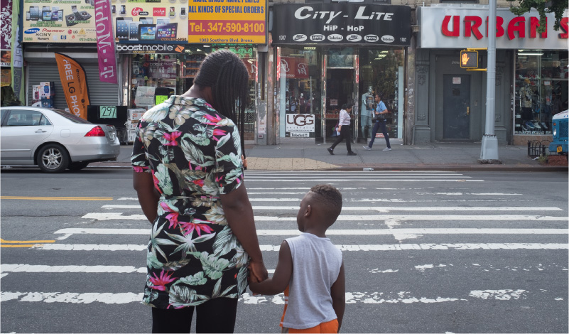 Photo of a mother and child waiting to cross the street
