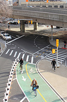 Cyclists ride on a two-way green bike path.