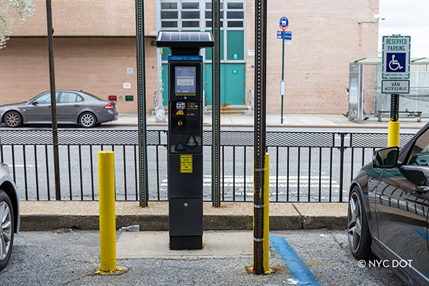 Pay-by-Plate parking meter pictured on the side of a street in Queens, New York.
