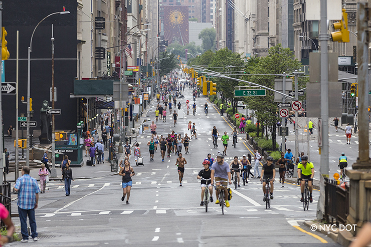 People walk, run and ride bicycles along Park Avenue in Manhattan during a car-free Summer Streets event