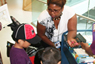 Bellevue Hospital Parent Educator Yanilda Gomez distributes books to children as part of a Reach Out and Read event sponsored by Children of Bellevue.